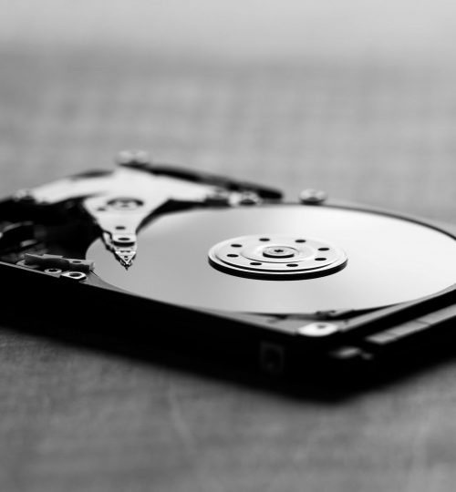 Artistic black and white shot of an open hard drive, showcasing internal components.